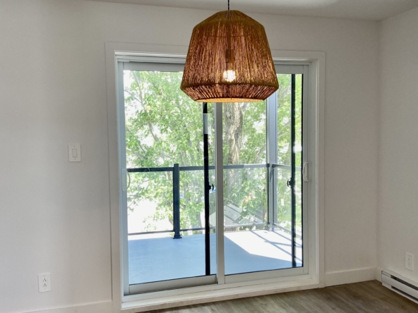 Salle à manger avec porte patio menant au balcon